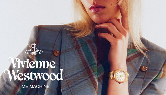 Close-up of model wearing Vivienne Westwood gold bracelet watch with white dial, styled with tartan blazer.